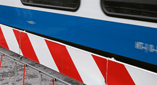 Rot-weiße Absperrschranke vor der blauen Außenwand eines Zuges der Bentheimer Eisenbahn AG