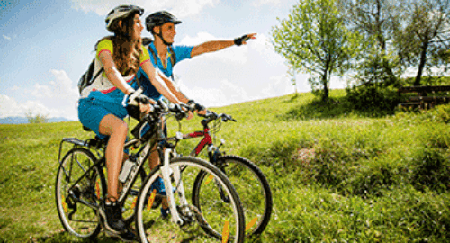 Radfahrer mit Helmen machen bei einer Fahrradtour Rast in der Natur
